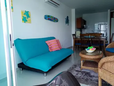 a living room with a blue couch and a table at Costa Azul Suites 1002 in Santa Marta