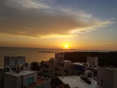 a sunset over a city with buildings and the ocean at Costa Azul Suite 606 in Santa Marta