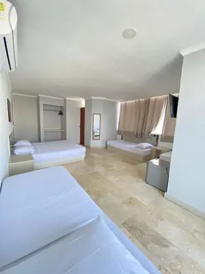 a white room with two beds and a couch at Hotel Cartagena Premium in Cartagena de Indias