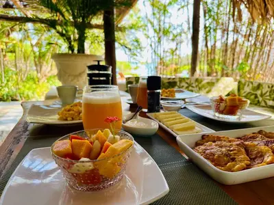a table topped with plates of food and a bowl of fruit at Hotel Playa Scondida Barú in Baru