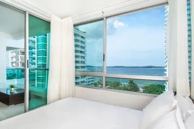 a bedroom with a large window with a view of the ocean at Travelers Orange Cartagena in Cartagena de Indias