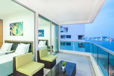a bedroom with a balcony with a view of the water at Travelers Orange Cartagena in Cartagena de Indias