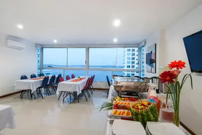 a dining room with tables and chairs and a large window at Travelers Orange Cartagena in Cartagena de Indias