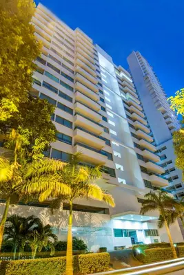 a tall building with palm trees in front of it at Travelers Orange Cartagena in Cartagena de Indias