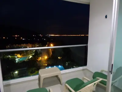 a balcony with chairs and a view of the city at Costa Azul Suites 906 in Santa Marta