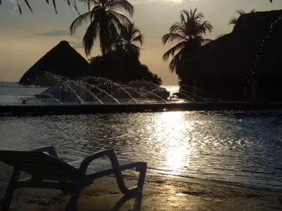 a chair sitting next to a pool with a fountain at Costa Azul Suites 906 in Santa Marta