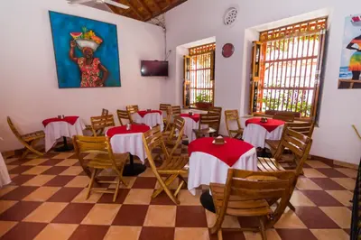 a room with tables and chairs in a restaurant at Hotel 3 Banderas in Cartagena de Indias
