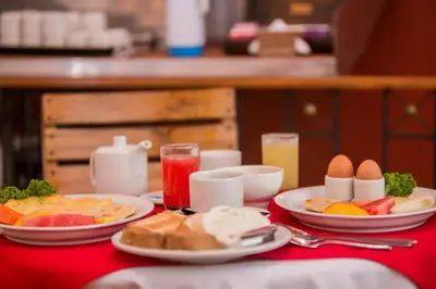 a table with plates of breakfast food on a red table cloth at Hotel 3 Banderas in Cartagena de Indias