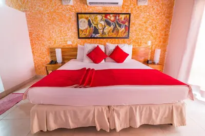 a bedroom with a large bed with red pillows at Hotel 3 Banderas in Cartagena de Indias