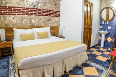 a bedroom with a large bed and a sink at Hotel 3 Banderas in Cartagena de Indias