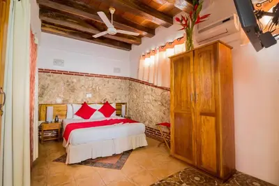 a bedroom with a bed with red pillows at Hotel 3 Banderas in Cartagena de Indias
