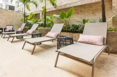 a row of chairs with pink pillows on a patio at Madisson Boutique Hotel Cartagena in Cartagena de Indias