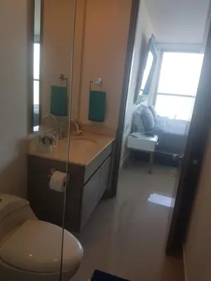 a bathroom with a sink and a toilet and a couch at Morros City - Frente al mar in Cartagena de Indias