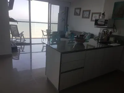 a kitchen with a counter and chairs in a room at Morros City - Frente al mar in Cartagena de Indias