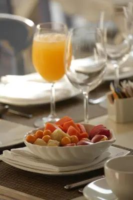 a table with a plate of food and a glass of orange juice at Hotel Casa Quero in Cartagena de Indias