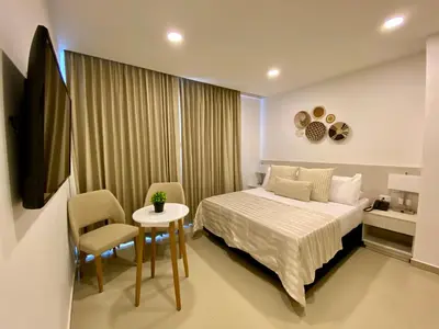 a bedroom with a bed and a table and chairs at Hotel Dorado Plaza Bocagrande - All Inclusive in Cartagena de Indias