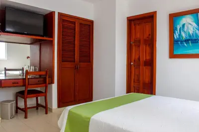 a bedroom with a bed and a desk and a television at Hotel Dorado Plaza Bocagrande - All Inclusive in Cartagena de Indias