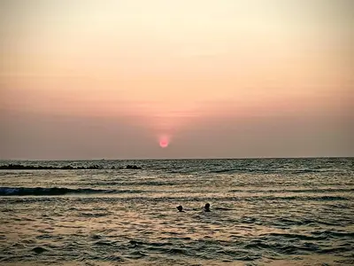 two people swimming in the ocean at sunset at Cabañas Cigua in Coveñas