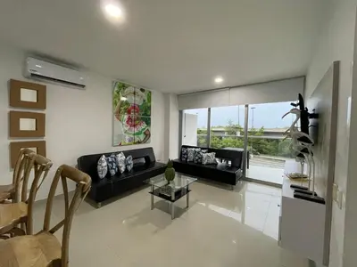 a living room with a black couch and a table at Apartamento Cartagena Morros Epic 23 in Cartagena de Indias