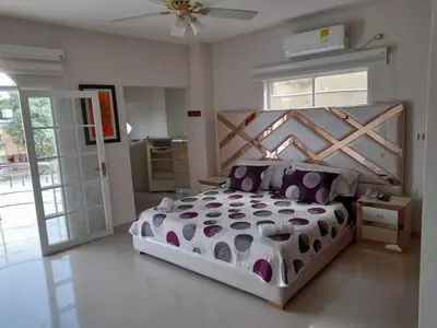 a bedroom with a large bed with a wooden headboard at Hotel Dainner in Plato