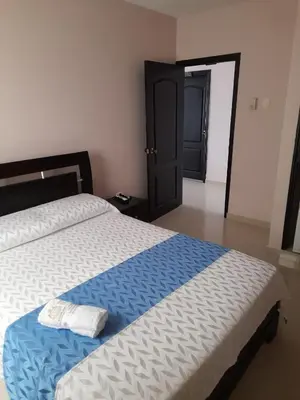 a bedroom with a large bed with two towels on it at Hotel Dainner in Plato