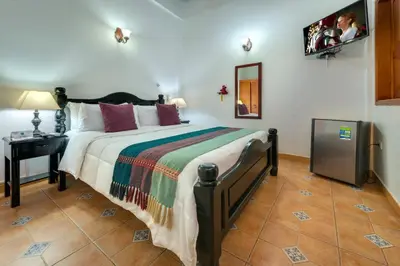 a bedroom with a large bed with a table and a mirror at Casa Del Curato in Cartagena de Indias