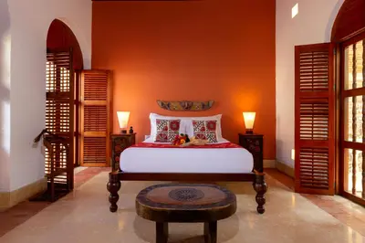 a bedroom with a white bed and two lamps at Hotel Quadrifolio in Cartagena de Indias