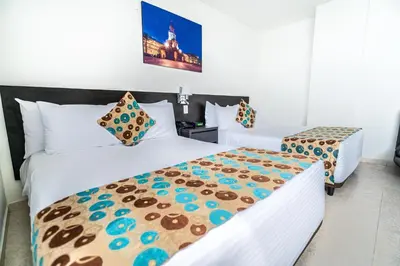 a hotel room with two beds with cookies on them at Hotel Cartagena Plaza in Cartagena de Indias
