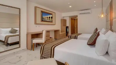 a hotel room with two beds and a desk at Hotel Cartagena Plaza in Cartagena de Indias