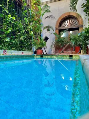 a large blue swimming pool with plants in a building at Hotel Don Pedro De Heredia in Cartagena de Indias