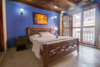 a bedroom with a bed with a blue wall at Hotel Don Pedro De Heredia in Cartagena de Indias