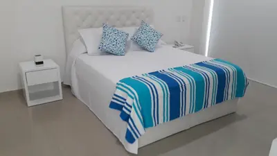 a bedroom with a white bed with blue pillows at Morros Epic 222 in Cartagena de Indias