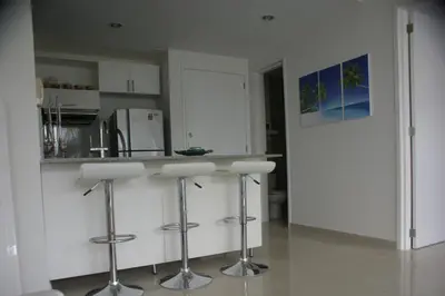 a kitchen with white cabinets and bar stools at Morros Epic 222 in Cartagena de Indias