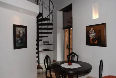 a dining room with a table and a spiral staircase at Alfiz Hotel in Cartagena de Indias