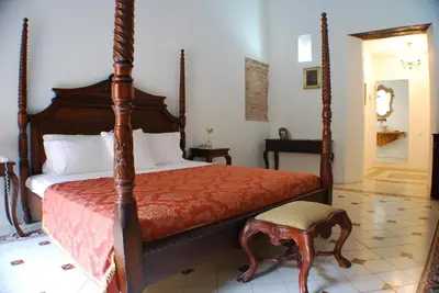 a bedroom with a bed with a red comforter at Alfiz Hotel in Cartagena de Indias