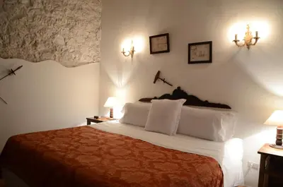 a bedroom with a bed with two lights on the wall at Alfiz Hotel in Cartagena de Indias