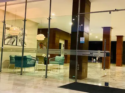a lobby with glass walls and furniture in a building at MORROS VITRI Luxury in Cartagena de Indias