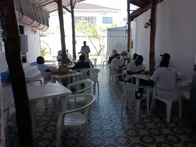 a group of people sitting at tables in a restaurant at Gran Muelle Hotel in San Bernardo del Viento
