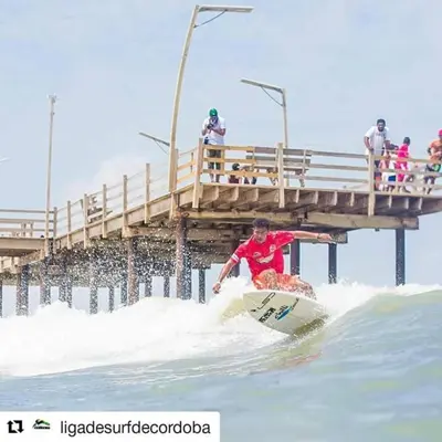 a man riding a wave on a surfboard in the ocean at Gran Muelle Hotel in San Bernardo del Viento