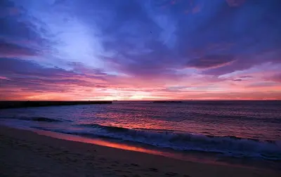 a sunset on a beach with the ocean and the sky at Gran Muelle Hotel in San Bernardo del Viento