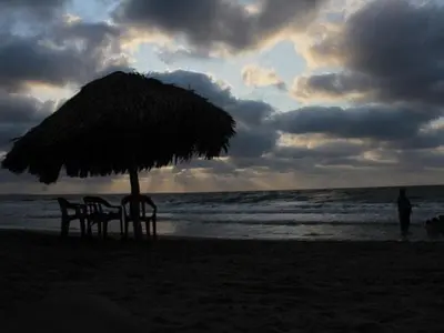 a table and chairs under an umbrella on the beach at Gran Muelle Hotel in San Bernardo del Viento