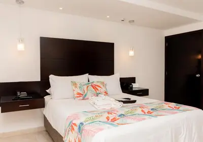 a bedroom with a large bed with a black headboard at Hotel Capilla del Mar in Cartagena de Indias