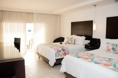 a hotel room with two beds and a window at Hotel Capilla del Mar in Cartagena de Indias