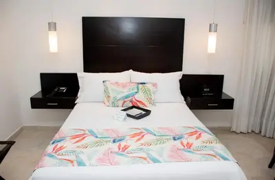 a bed in a hotel room with two night stands at Hotel Capilla del Mar in Cartagena de Indias