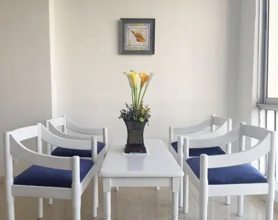 a table with three chairs and a vase with flowers on it at Apartamento con hermosa vista y cerca de playas in Cartagena de Indias