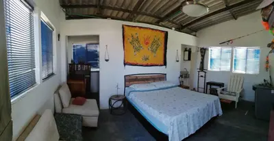 a bedroom with a bed and a couch and windows at Galerazambahostal in Galerazamba