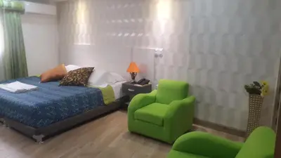 a bedroom with a bed and a green chair at Hotel Damys in Sincelejo