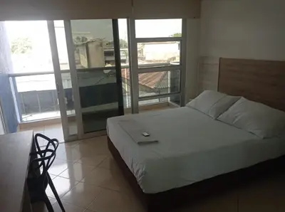 a bedroom with a bed and a large window at Hotel Damys in Sincelejo