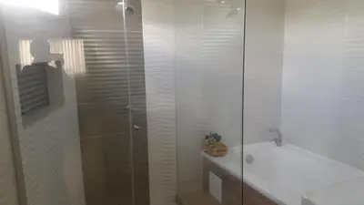 a bathroom with a shower and a tub and a sink at Hotel Damys in Sincelejo