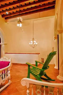 a room with a green table and a bench at Casa D´Remedios La Bella Hotel Boutique in Ciénaga